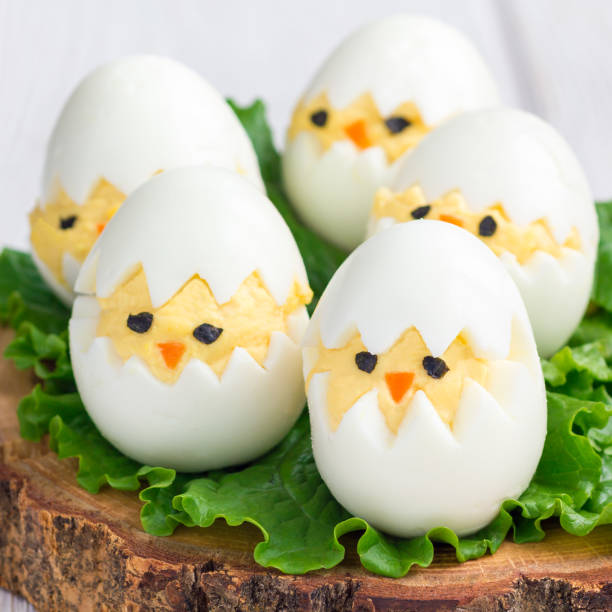 galinha no ninho, muito apimentado ovos, servidos com salada na placa de madeira, formato quadrado - deviled - fotografias e filmes do acervo