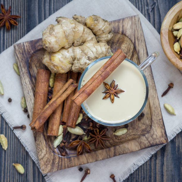 istock Masala chai with spices on wooden background, square format, top view 851979252