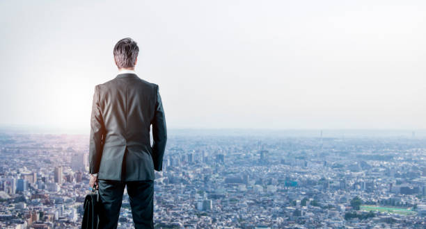 istock businessman looking down a modern city. business prospect concept. 851981248