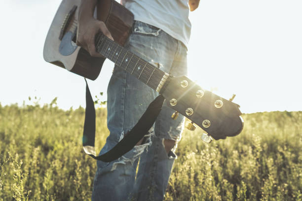 istock low section of man walking in field with guitar 851993538