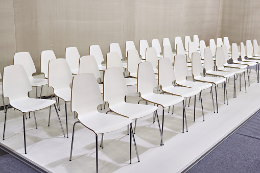 Rows of white chairs in the presentation room