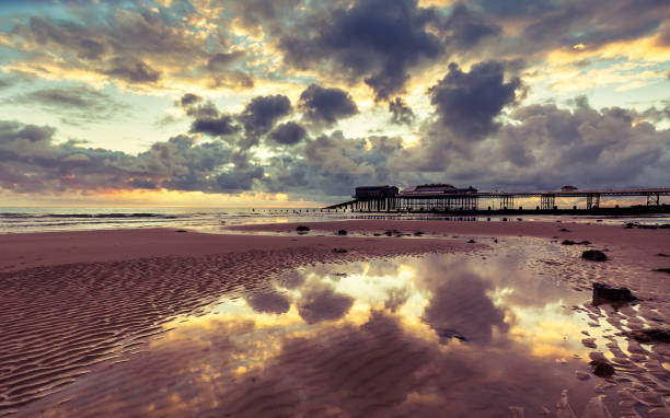 Cromer Pier at sunrise, Norfolk,uk Tides out and the sun rises on Cromer beach, Norfolk, uk crabbing stock pictures, royalty-free photos & images