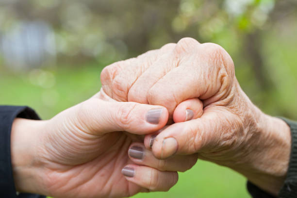 istock Senior & young woman holding hands 852000692