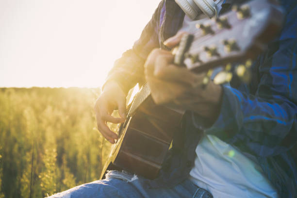 istock closeup of man hands playing guitar in field 852003590
