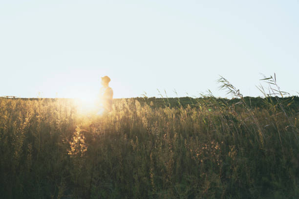 istock young man sitting in grassy field playing guitar 852003762