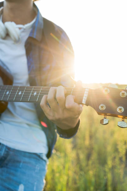 istock closeup of man hands playing guitar in field 852016462
