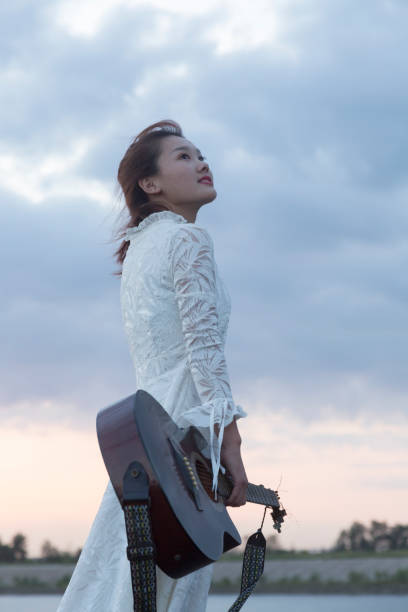 istock pretty woman carrying guitar walking against sky 852024906