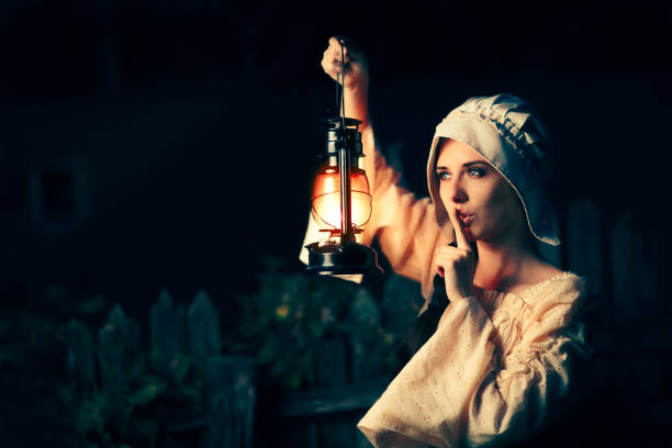 램프를 들고 입술에 손가락으로 중세 여자 - beauty witch beautiful women 뉴스 사진 이미지
