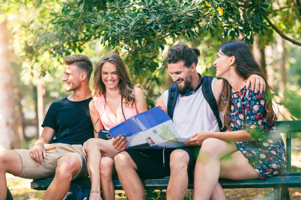 istock Four smiling traveling young people with map 852027876
