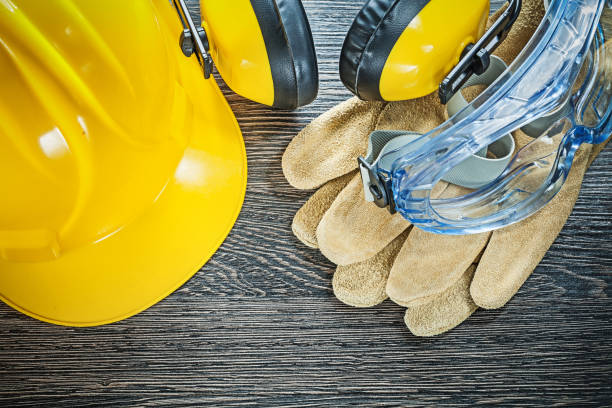 istock Safety cap leather gloves goggles earmuffs on wooden board 852028048