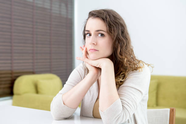 istock Serious Pretty Woman Sitting at Table at Home 852028886