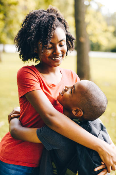istock brother and sister embracing at the park 852030156