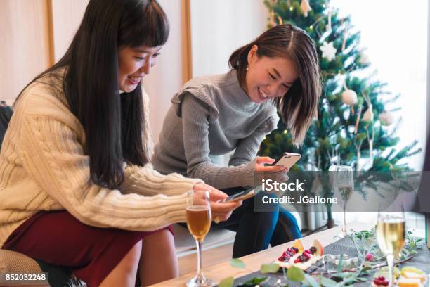 Two Young Women Taking Photos Of Their Food At Christmas Stock Photo - Download Image Now