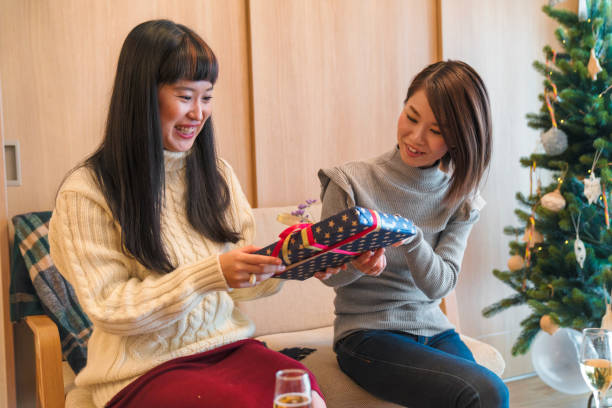 istock Young female friends exchanging Christmas presents 852032274