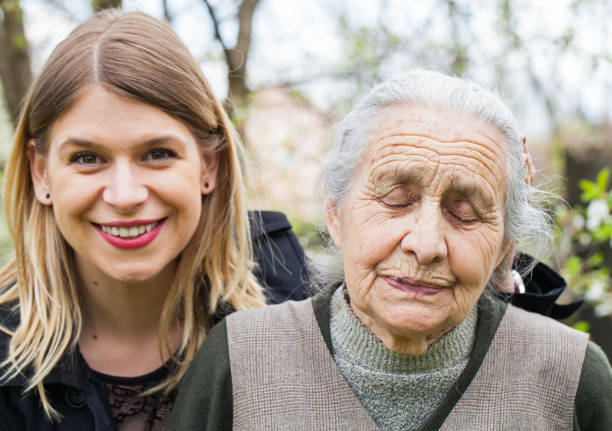 istock Sick old lady with her joyful carer 852036440