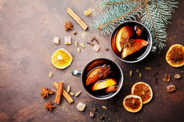 two cups of christmas mulled wine or gluhwein with spices and orange slices on rustic table top view. traditional drink on winter holiday. - hot drink fotos imagens e fotografias de stock