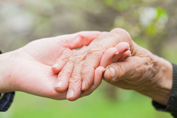 istock Senior & young woman holding hands 852039122