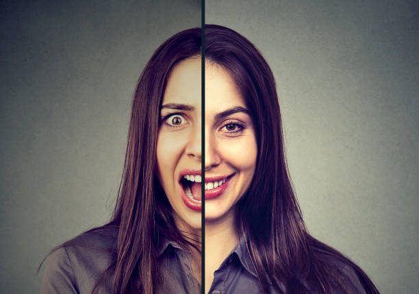 Bipolar disorder and split personality concept. Woman with double face expression isolated on gray background Bipolar disorder and split personality concept. Woman with double face expression isolated on gray background bipolar disorder stock pictures, royalty-free photos & images