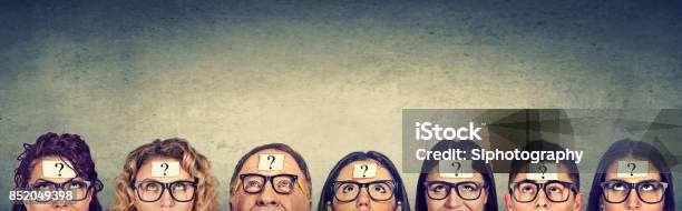 Multiethnic Group Of Thinking People In Glasses With Question Mark Looking Up Stock Photo - Download Image Now