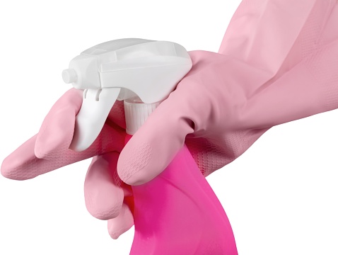 Hand in glove holds spray bottle. Isolated on a white background.