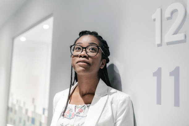 young pensive brazilian businesswoman looking up in office - braids african descent women pensive imagens e fotografias de stock