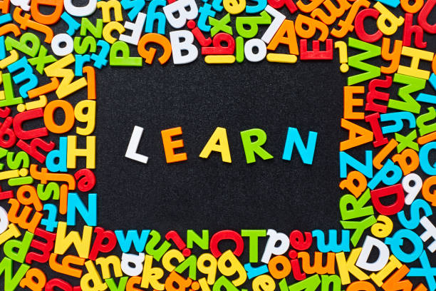 istock Overhead view of learn text amidst colorful alphabets on blackboard 852059482