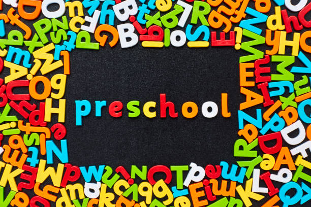istock Overhead view of preschool text amidst colorful alphabets on blackboard 852060064