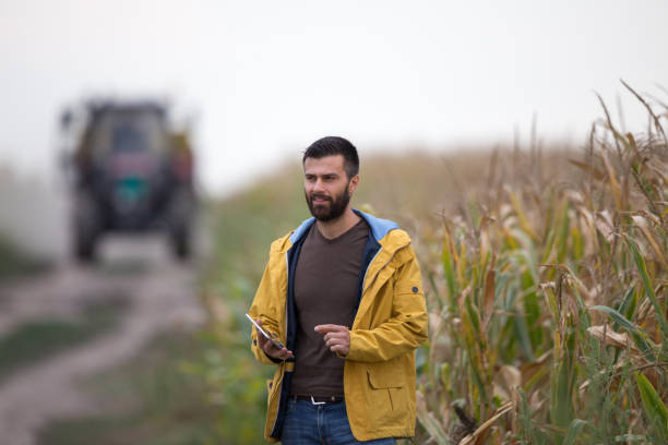 istock Farmer in front of tractor in field 852067882