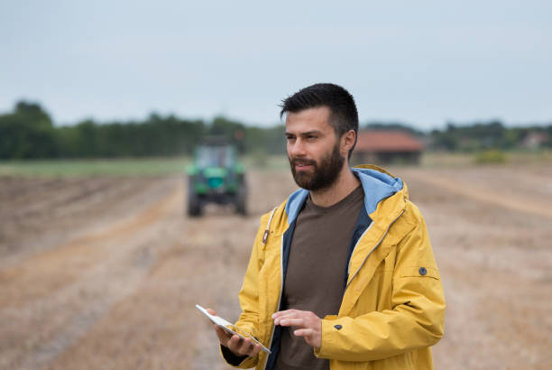 istock Farmer in front of tractor in field 852068138