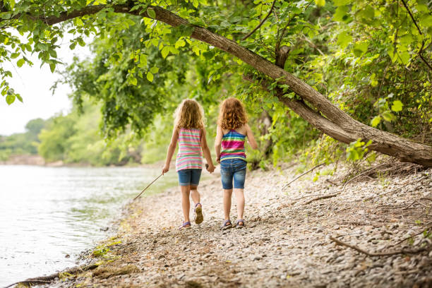 istock Two Young Girls Walking Along River Bank 852073438
