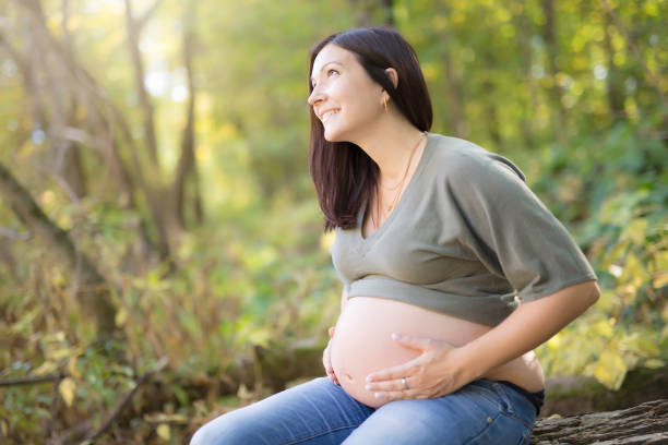 istock Beautiful pregnant woman relaxing on a park 852073668
