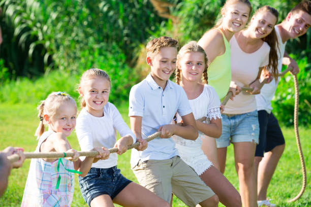 istock Friendly kids with parents playing tug of war 852075546