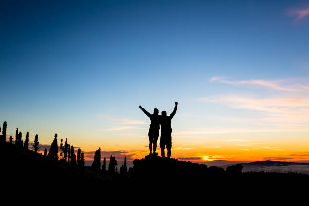 istock Teamwork couple climbing and reaching mountain peak 852084564