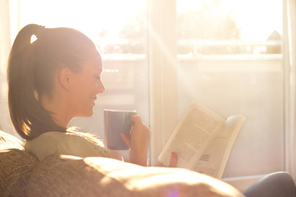 istock Woman reading book and drinking coffee 852088036