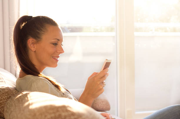 istock Woman with mobile phone on sofa 852088082
