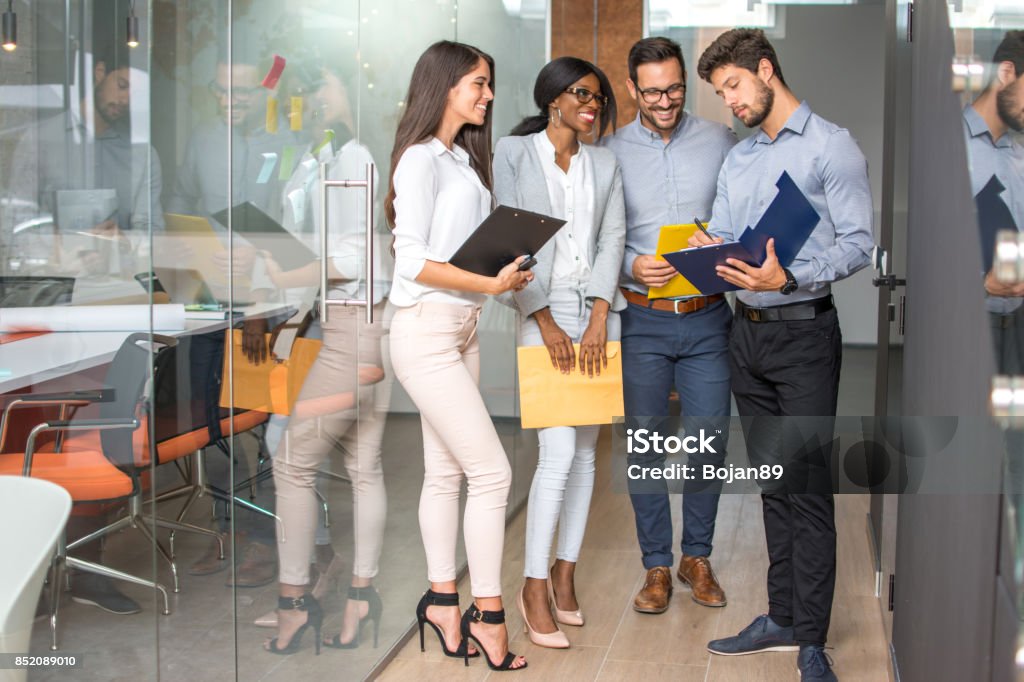 Group of business people going through paperwork in office hall. Discussion Stock Photo