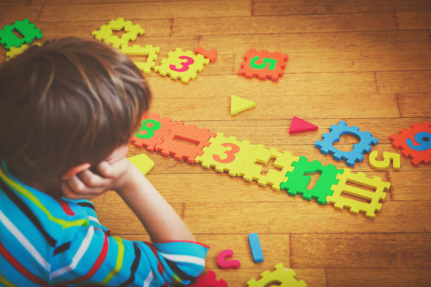 istock little boy playing with puzzle, education concept 852092384