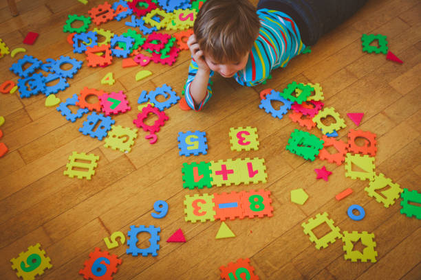 istock little boy playing with puzzle, education concept 852092692