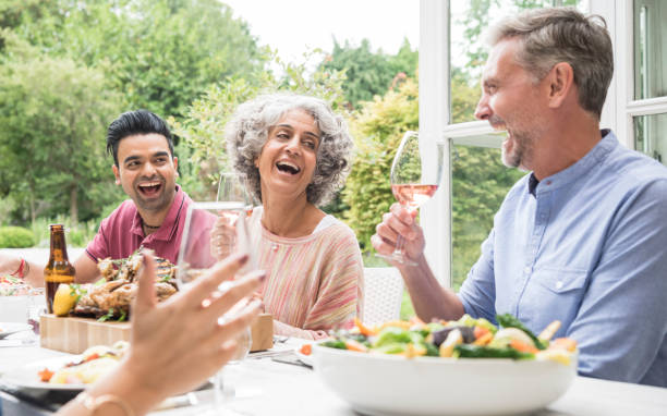 istock Three friends laughing over dinner in garden 852102558