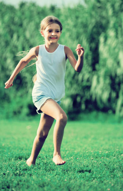 istock girl running and jumping on grass 852103592