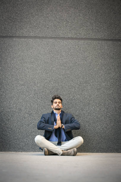 istock Caucasian businessman practicing yoga on sidewalk. Space for copy. 852107386
