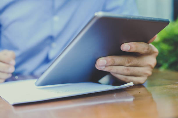 istock Business man working on digital tablet and writing document in street cafe. Close up 852109826