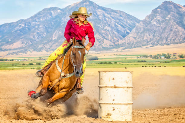 jeune femme dirige son cheval autour d’un baril pendant un concours de course de baril - women bride personal accessory adult photos et images de collection