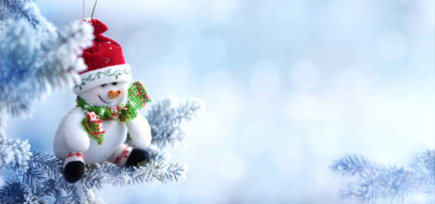 istock Christmas Snowman Hanging on a Snow Tree Branch 852131834