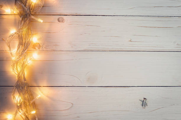 istock christmas background and lights garland on wood background with space. 852134408