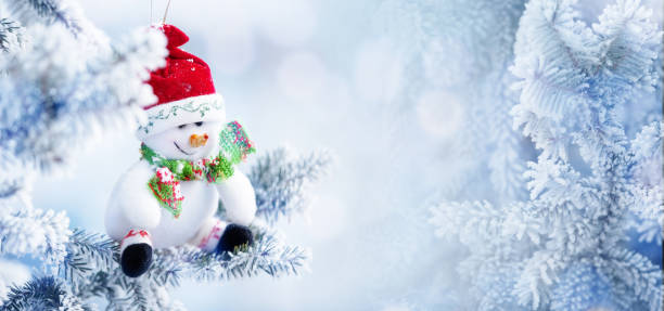 istock Christmas Snowman Hanging on a Snow Tree Branch 852135088