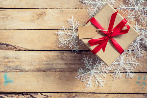 istock Christmas gift boxes placed and white snowflakes on wooden planks with space. 852138214