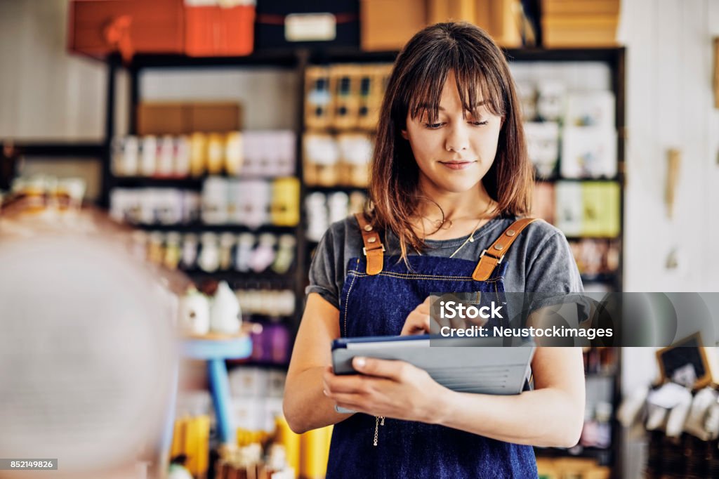 Confiance aux jeunes entrepreneurs à l’aide de tablette numérique en épicerie fine - Photo de Liste de choses à vérifier libre de droits