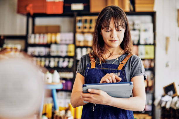 Confident young entrepreneur using digital tablet in delicatessen