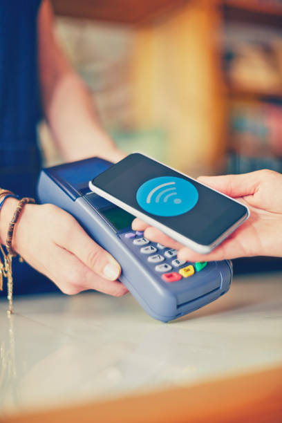 istock Customer placing Wi-Fi connected smartphone over card reader in 852152508